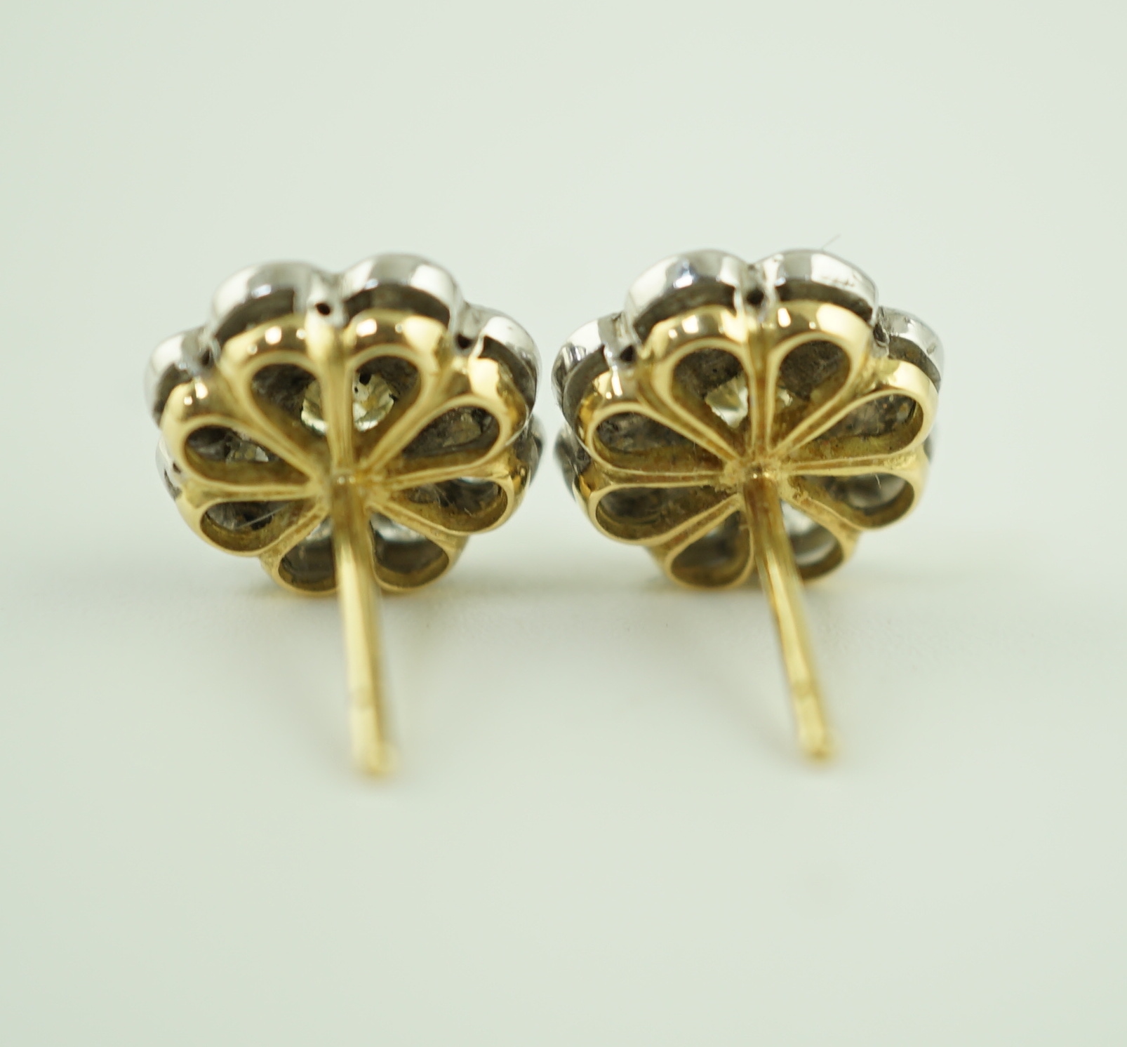 A pair of gold and nine stone diamond cluster set flower head ear studs